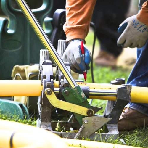close up of a plumber about to trim an external gas line prior to installing in a trench in spring hill, ks