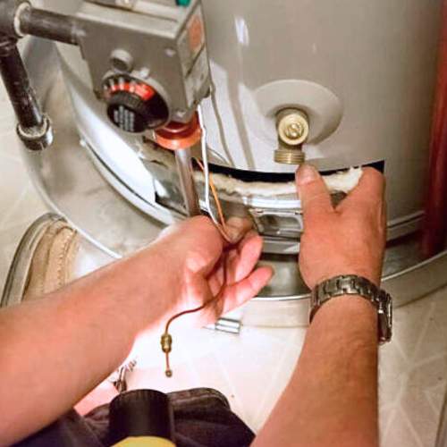 a hot water heater being repaired by a plumber in paola, ks