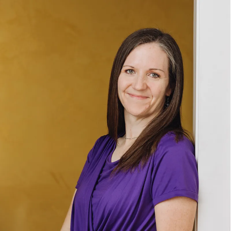 Portrait of Krista with a calm smile, representing her journey from burnout to an effortless intuitive life for moms