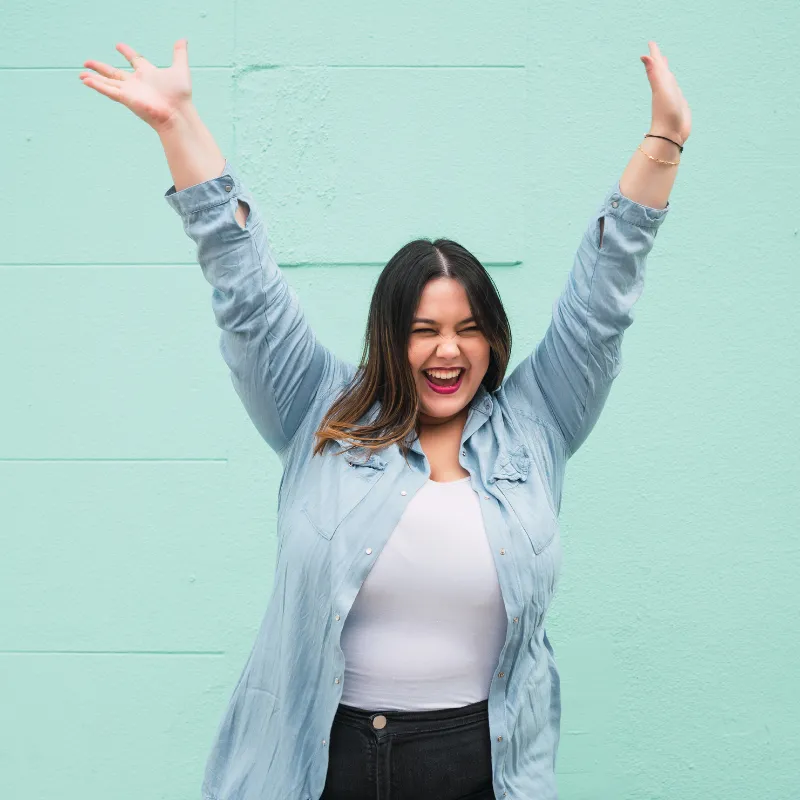 Woman celebrating success, representing real-life stories and mini miracles for moms following the effortless path