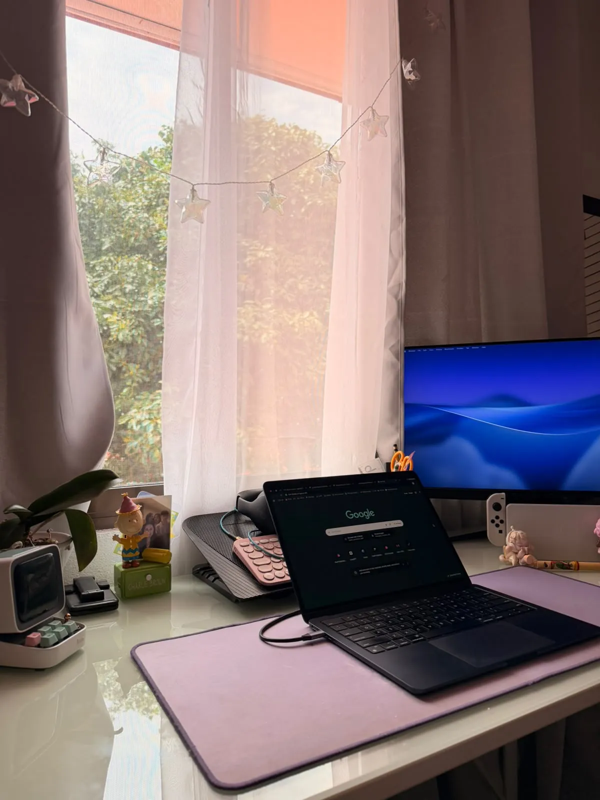 Polaroid-style photo of a desk setup with multiple monitors and posters on the wall, taped at the corners
