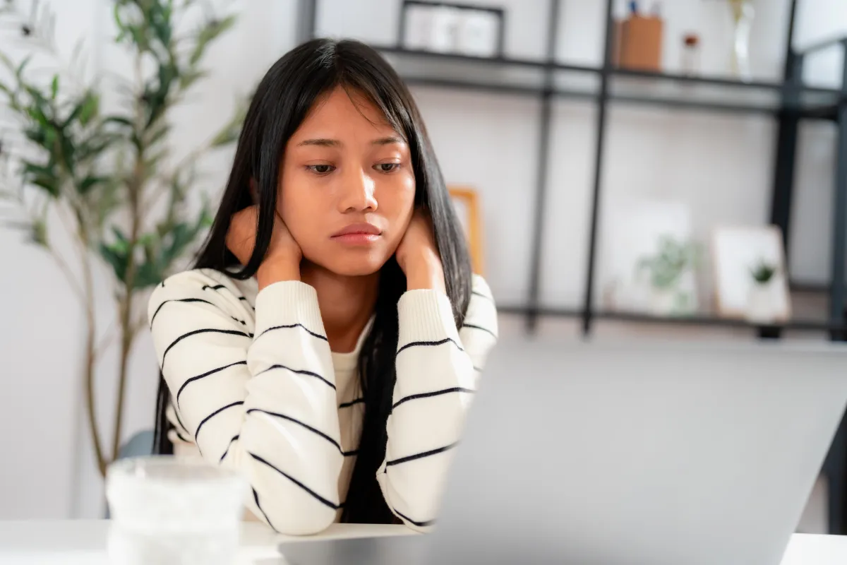 Business owner looking at laptop with a frustrated expression on their face as sales have slowed