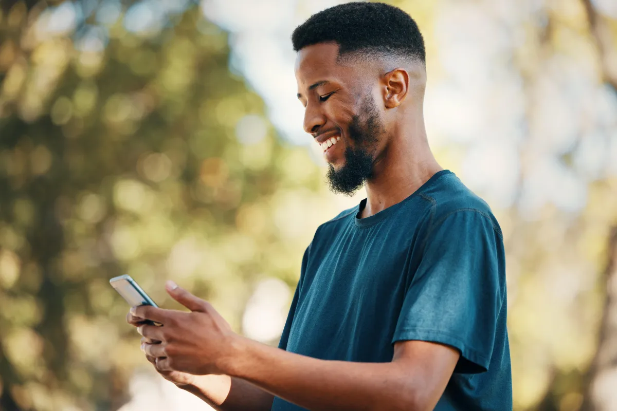 smiling business owner looking at his phone now sales are coming in while he lives his life