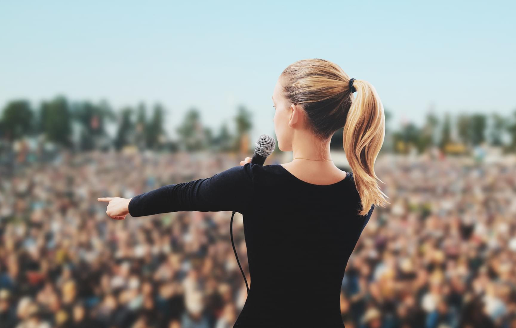 Woman speaking to a crod from stage in a stadium