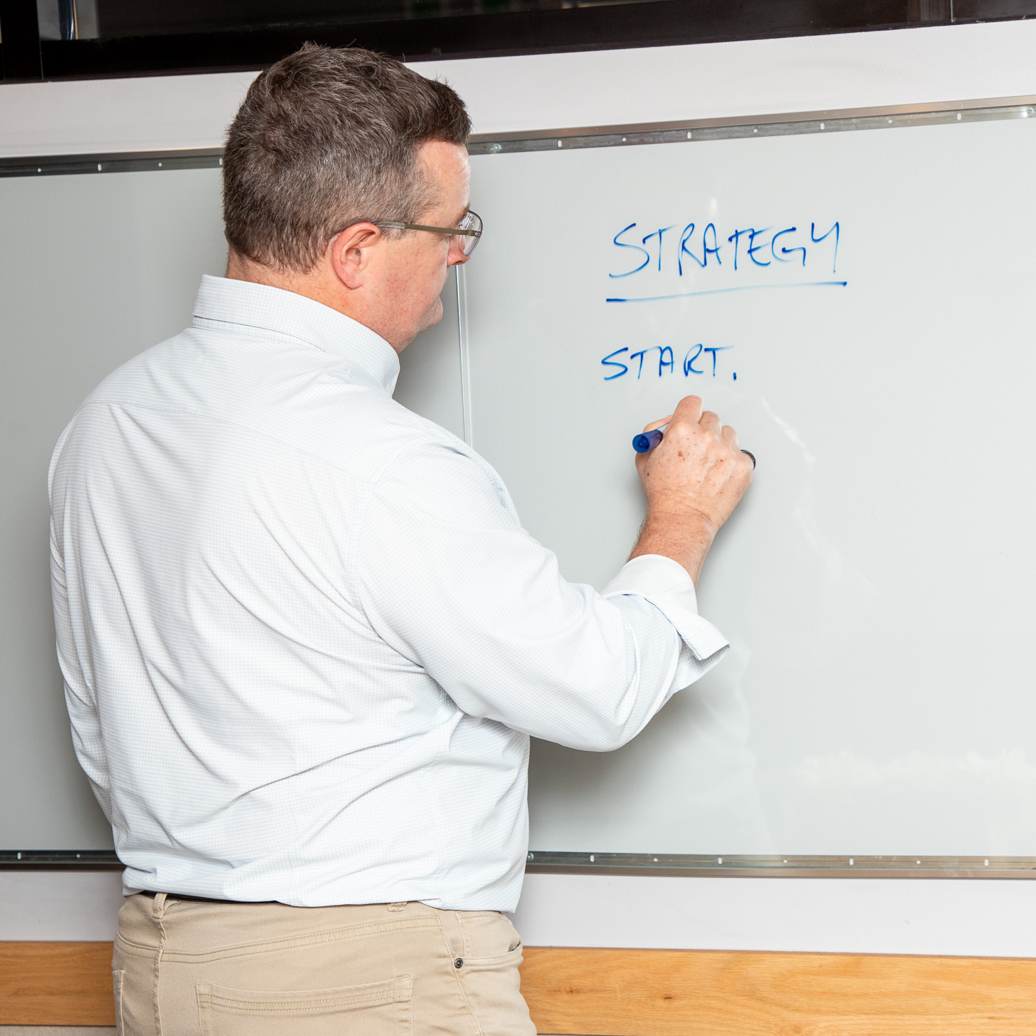 Paul at a whiteboard sketching strategic plans with a business owner during a one-on-one advisory session.
