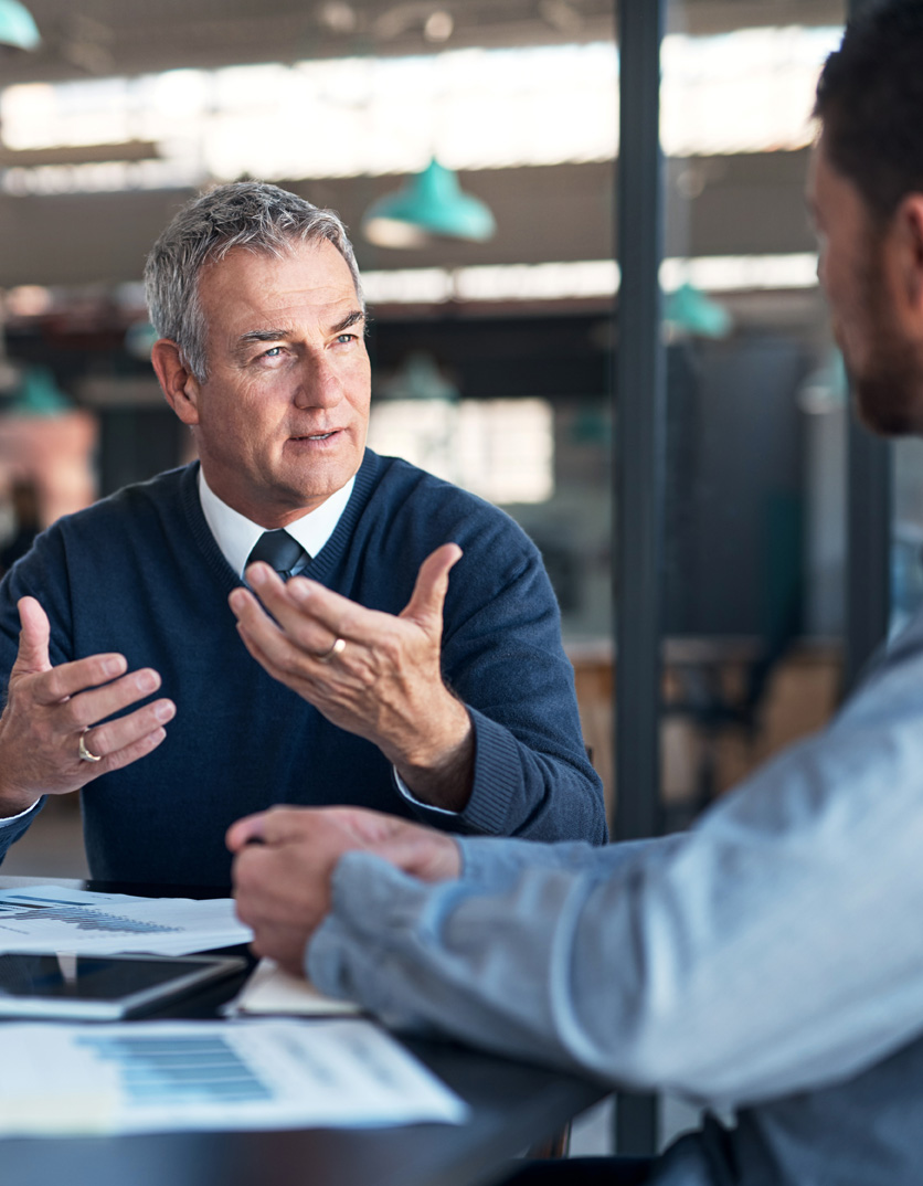 An operations director leading a meeting with cross-functional team members.