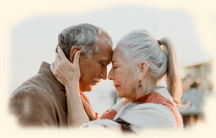 older couple, foreheads pressed together, both have eyes closed