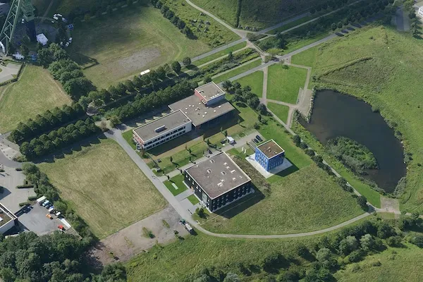 Aerial view of a building complex surrounded by green grounds
