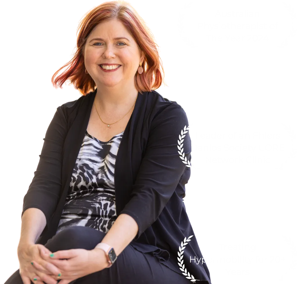 Sharon a woman with red hair wearing a black suit jacket and a zebra shirt. Australian physiotherapy of the year 2024, leader of an ehlers danlos society core network clinic, treating hypermobility for twenty plus years.