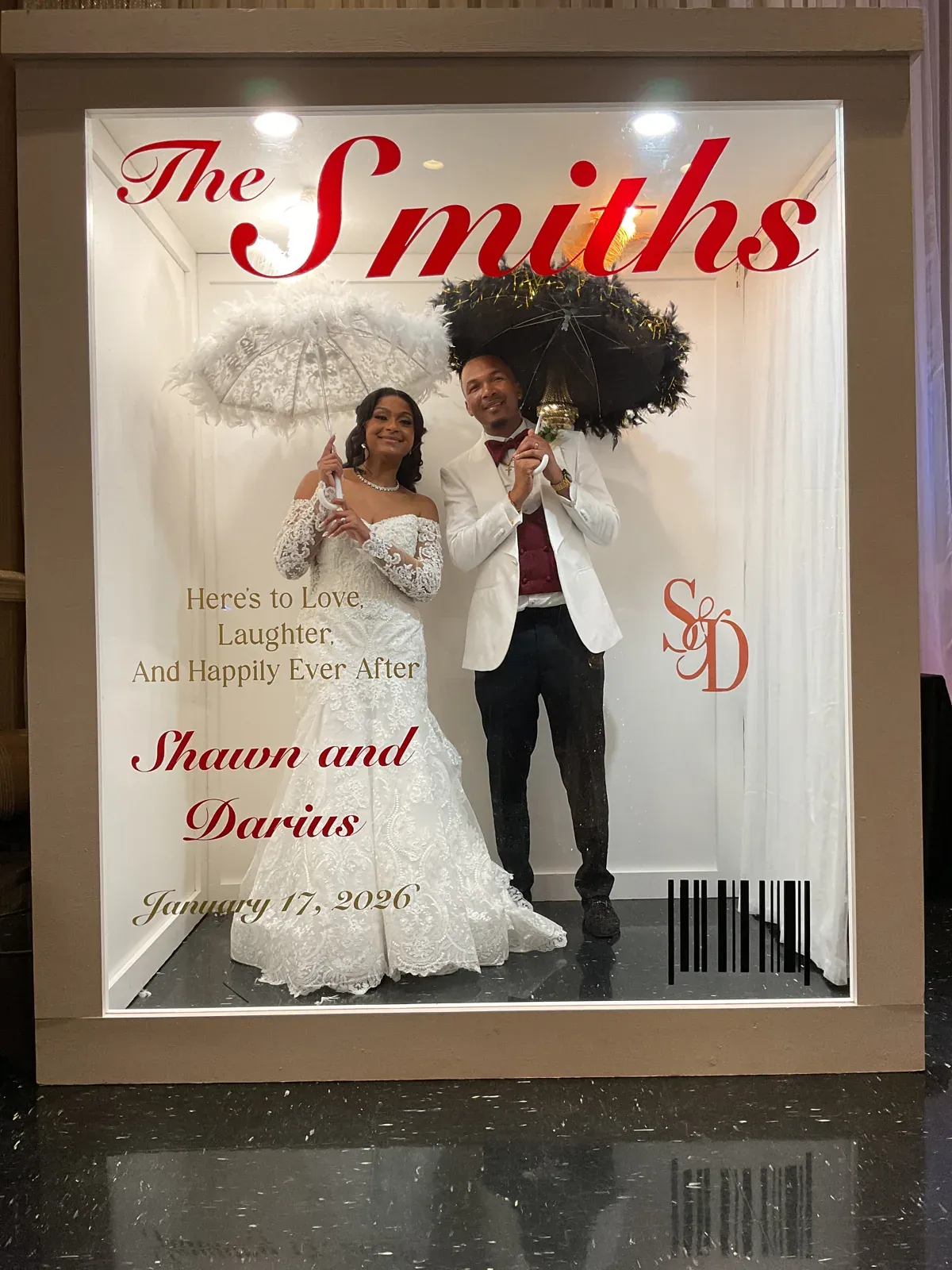 Bride and groom posing inside a customized Smiths magazine cover photo booth