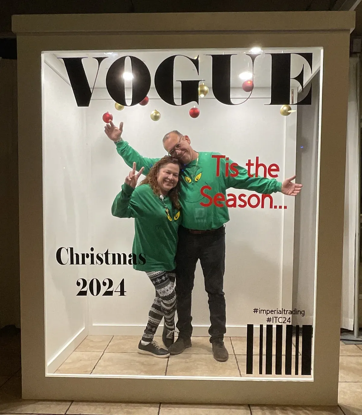 Two guests posing inside a holiday Vogue magazine cover photo booth