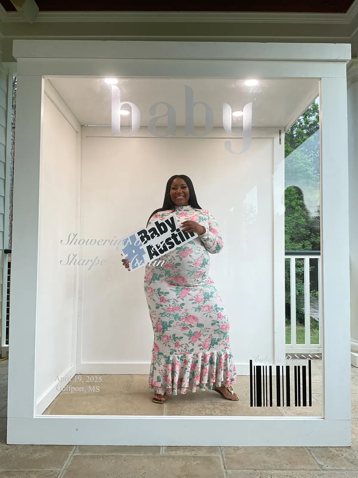 Guest in a floral dress posing inside a customized magazine cover photo booth