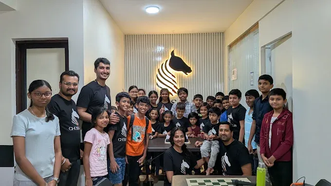 CHESS KLUB students smiling in front of the CHESS KLUB logo