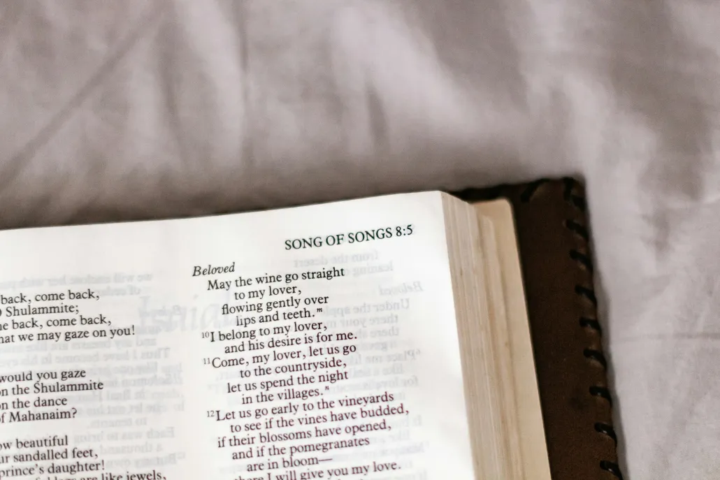 Open Bible on a gray fabric surface, showing the heading “Song of Songs 8:5” with text highlighted in the center column.