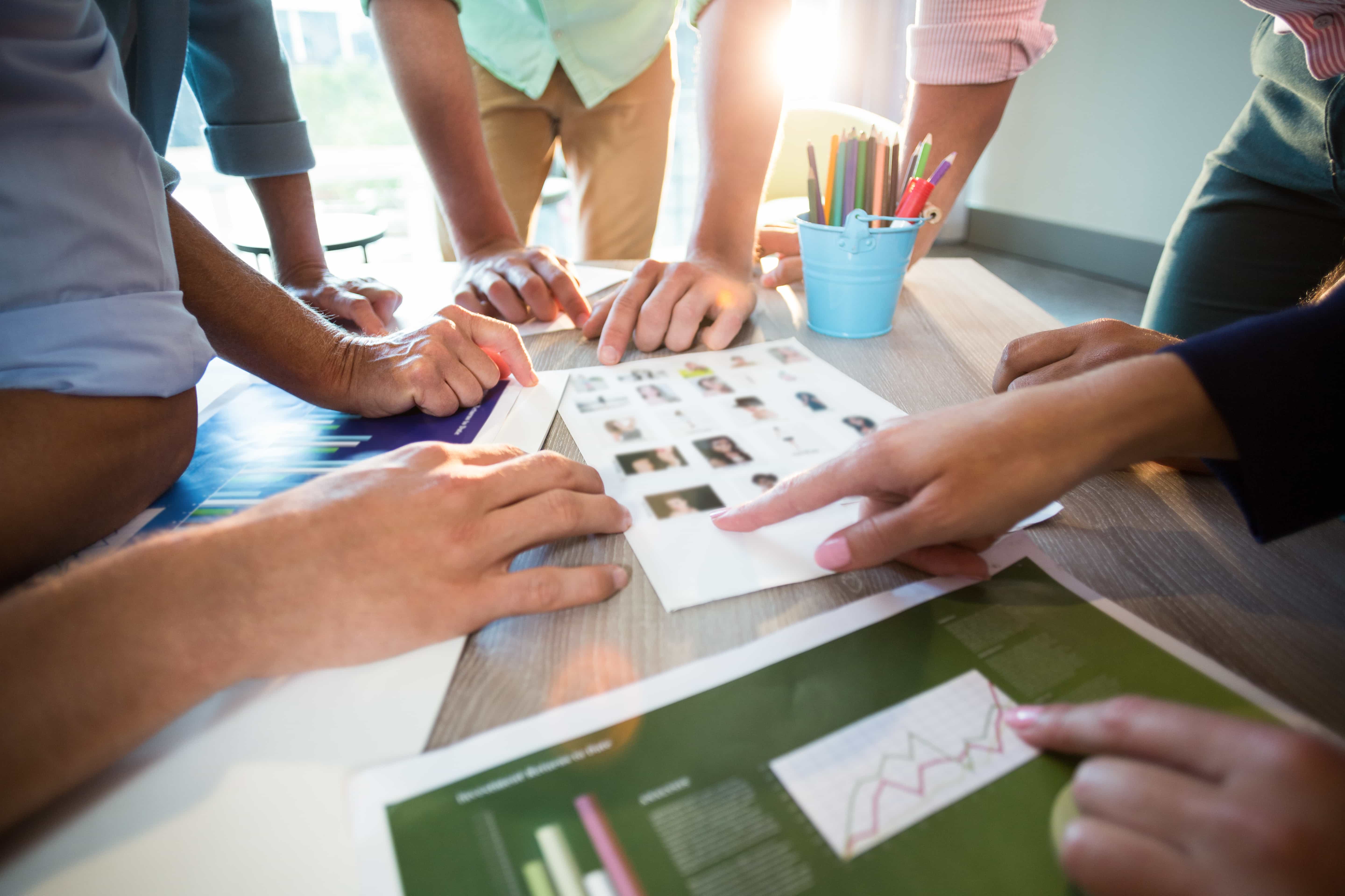 A creative team reviewing data charts and target audience profiles for a Digital Marketing Strategy planning session in Florida.