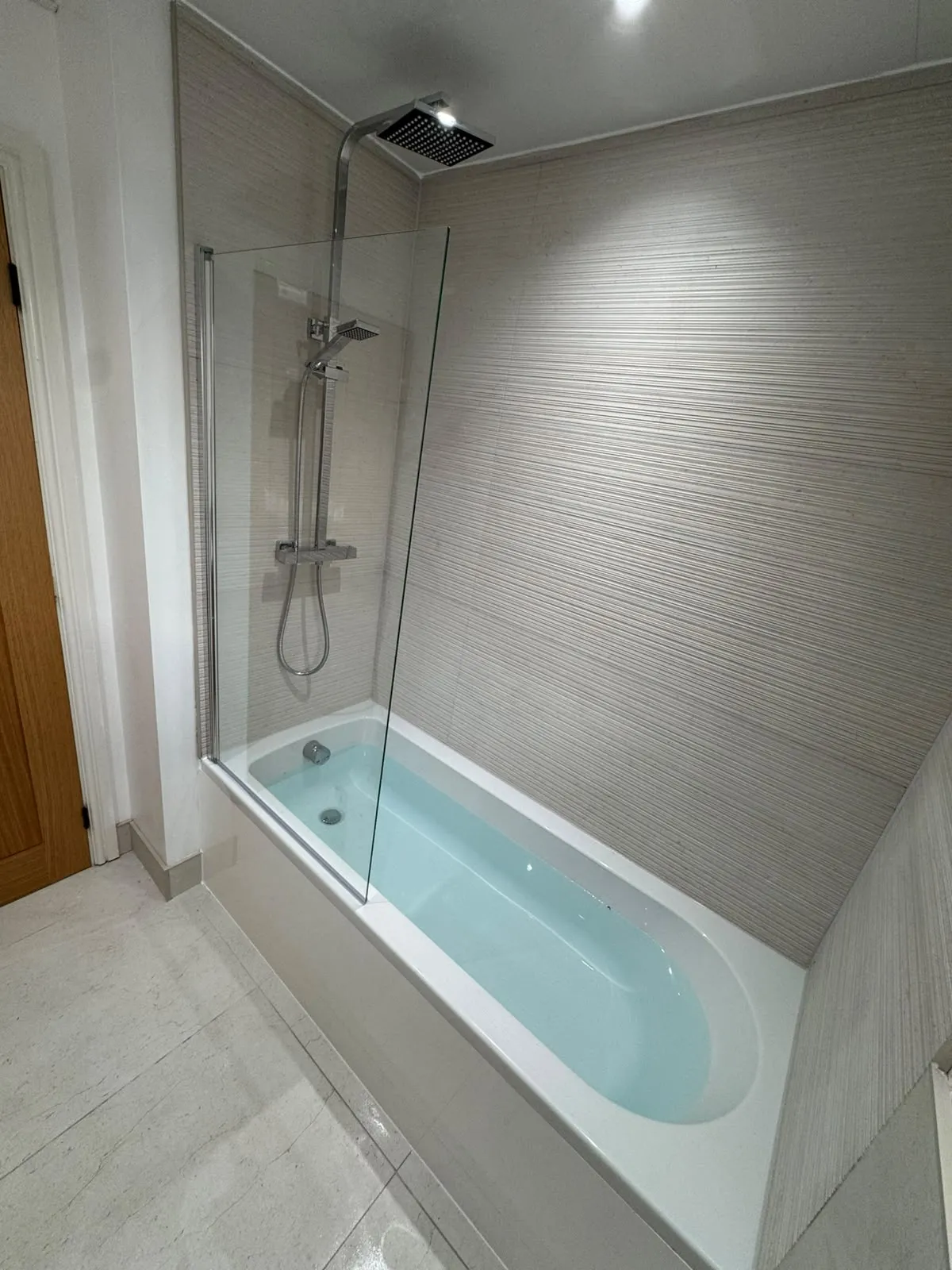 Compact bathroom with a curved glass shower enclosure and basin