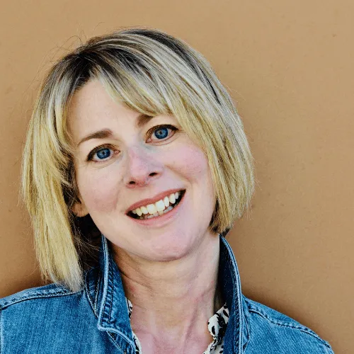 Kim Ribich, founder of Inner Wild Coaching, sitting outdoors with her dog Magnus