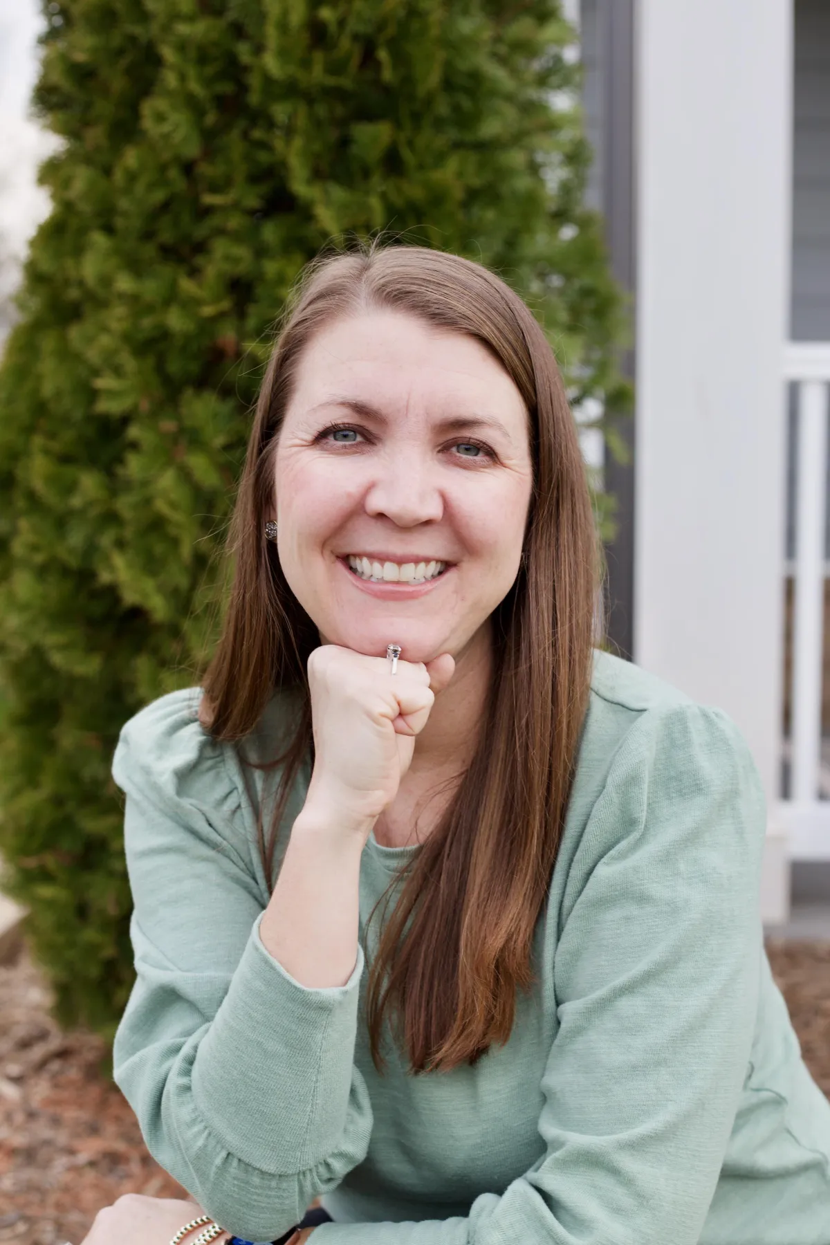 Rebecca smiling with her hand in fist up to her chin