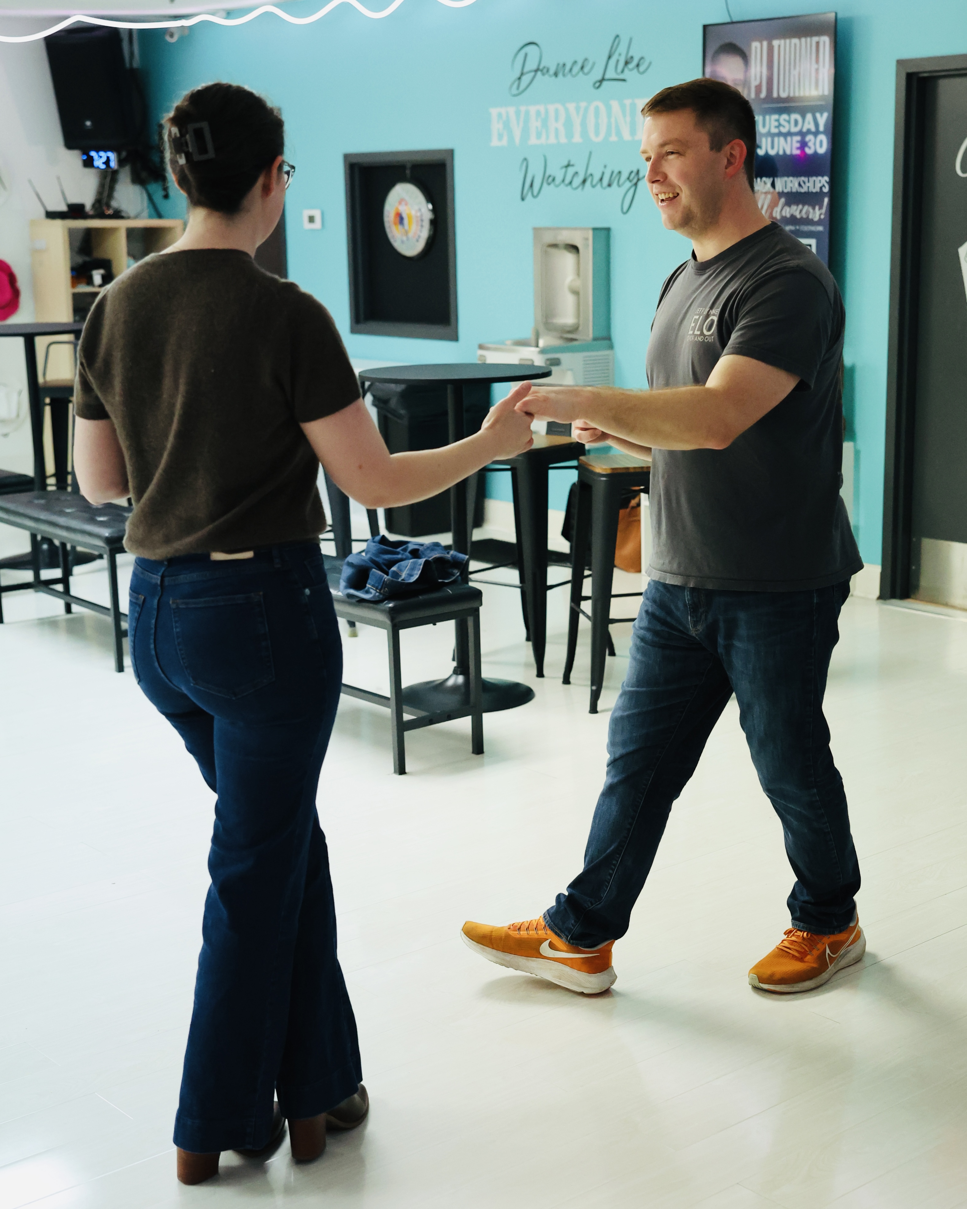 Two partners holding hands and dancing together at the Turn Their Heads studio in Nashville