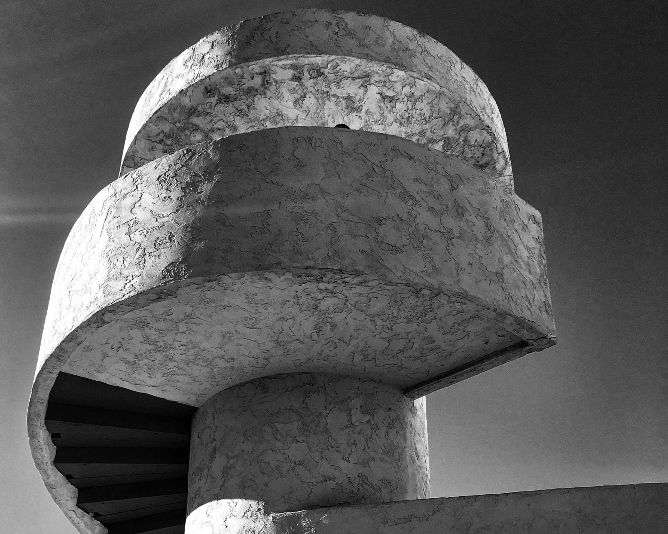 Residencia de autor minimalista, piedra clara y madera con interiores luminosos.