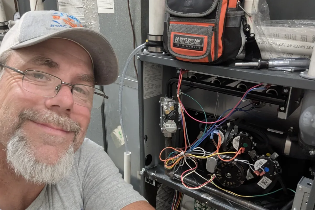 HVAC technician inspecting furnace in Topeka, KS, providing heating and plumbing services.