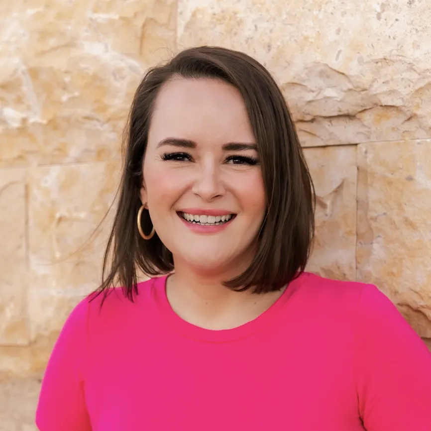 Colorful background of Andrea, smiling, holding her cellphone and posing for a selfie