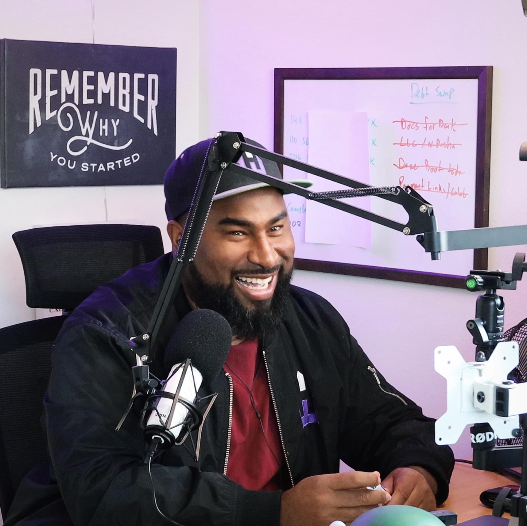 Photo of Henry Washington sitting at this desk on a podcast