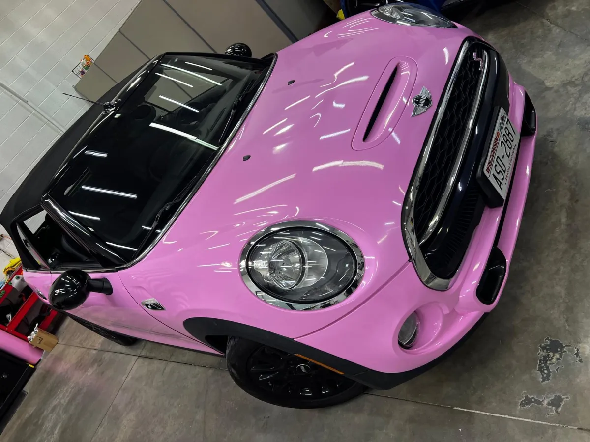 " Professional Car Wrap Installation service on a Mini Cooper Pink color by GB Enterprises AutoCare, located in Green Bay, WI . High-quality application on vehicle, demonstrating expert craftsmanship and attention to detail."