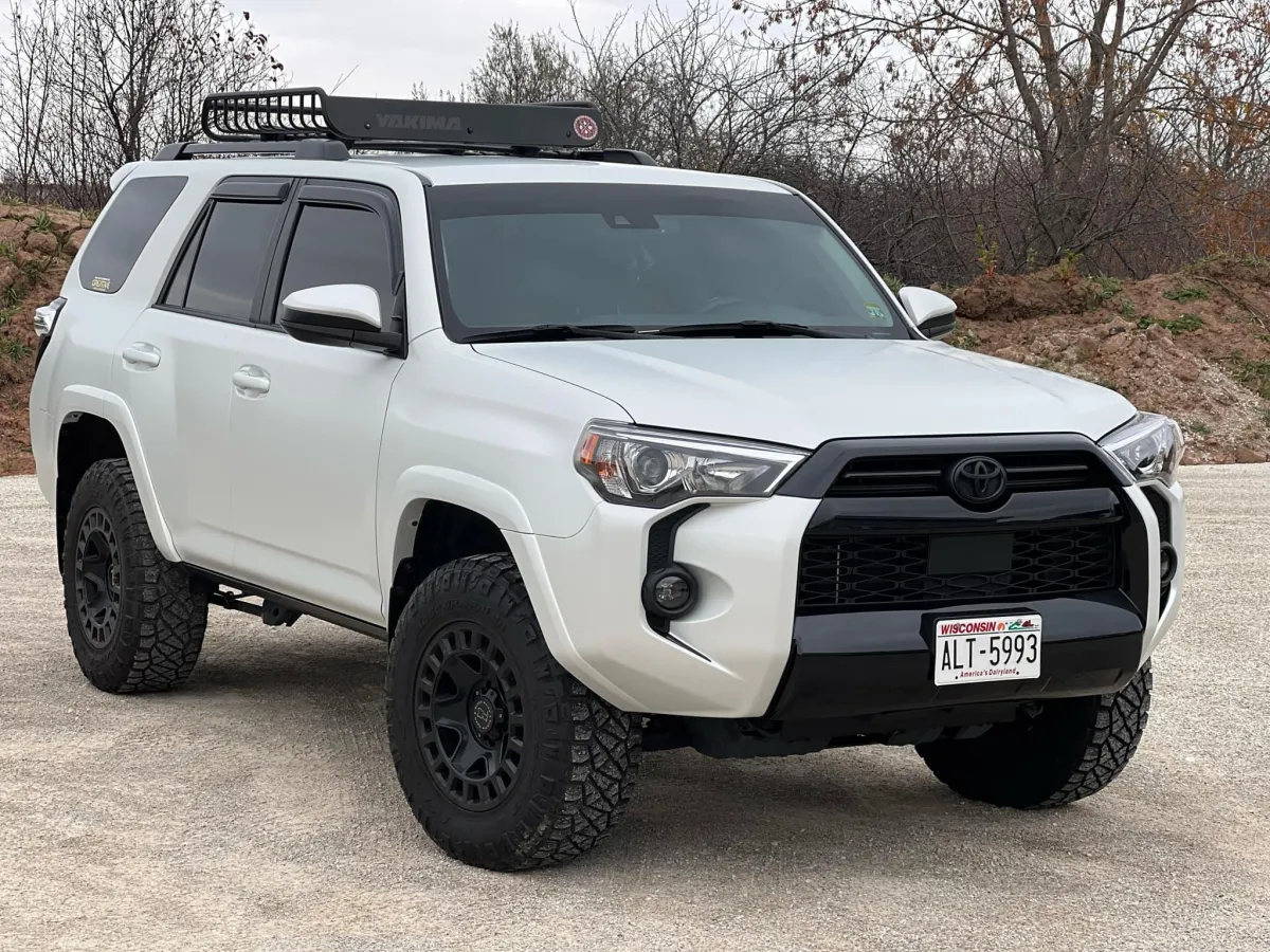 "White Toyota 4Runner SUV with custom window tinting by GB Enterprises AutoCare, featuring rugged off-road tires, roof rack, and Wisconsin plates, showcasing expert automotive care."