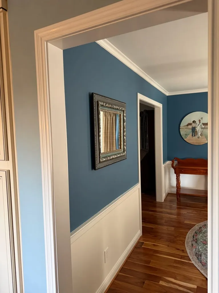 Hallway with blue painted walls, white trim and wainscoting