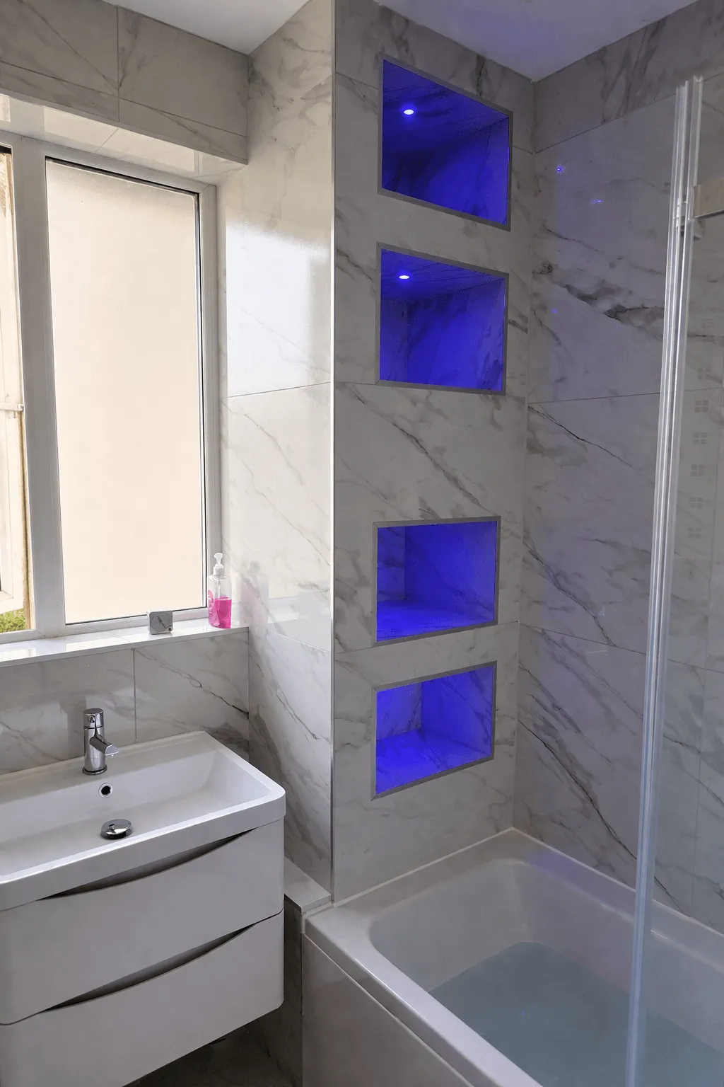 Marble bathroom renovation with LED niche lighting and bath by Willis Building Services London