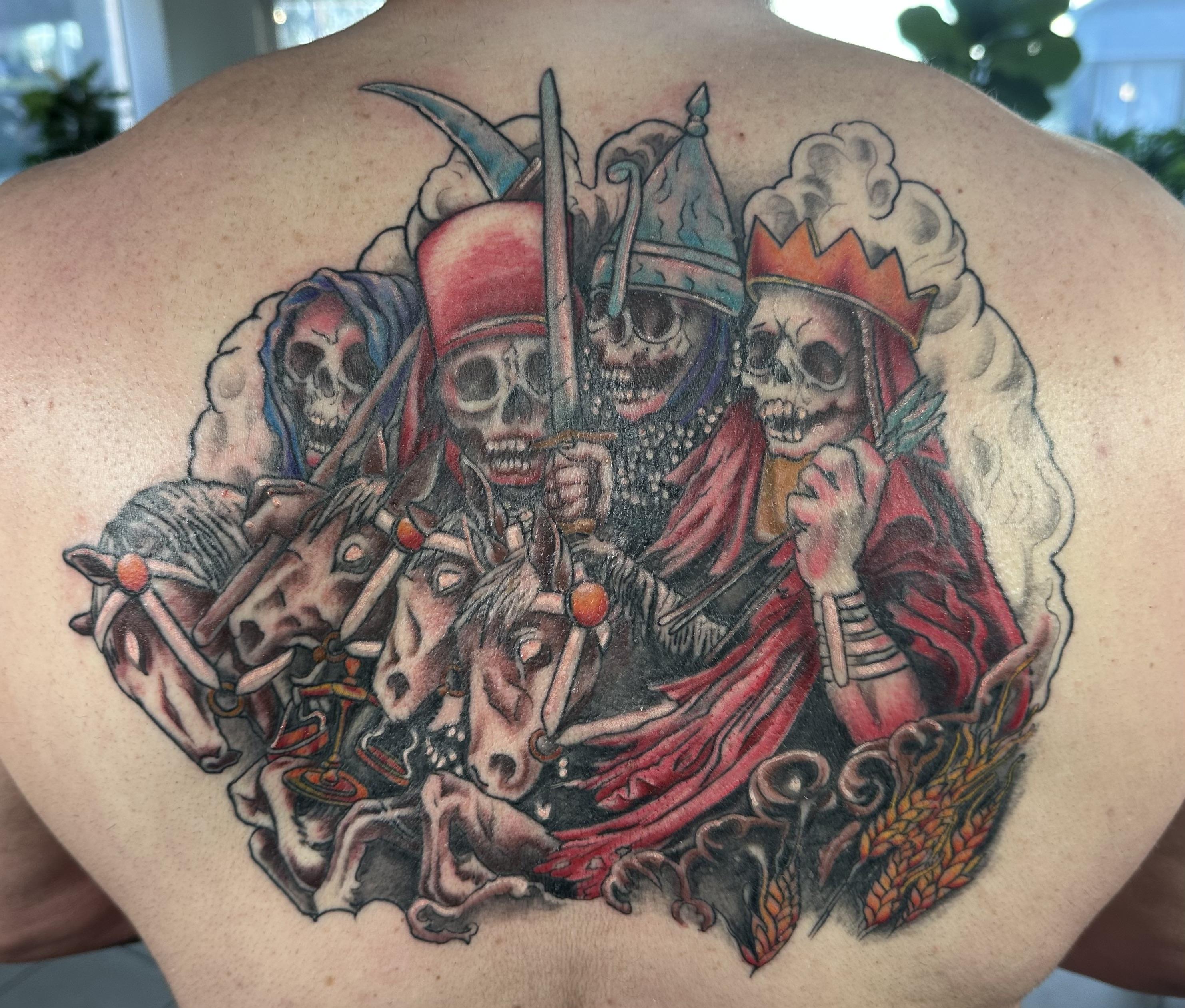 Close-up of a forearm tattoo featuring intricate geometric patterns in black ink, photographed in soft natural light. The background is a blurred studio setting with warm neutral tones. 1:1 aspect ratio.