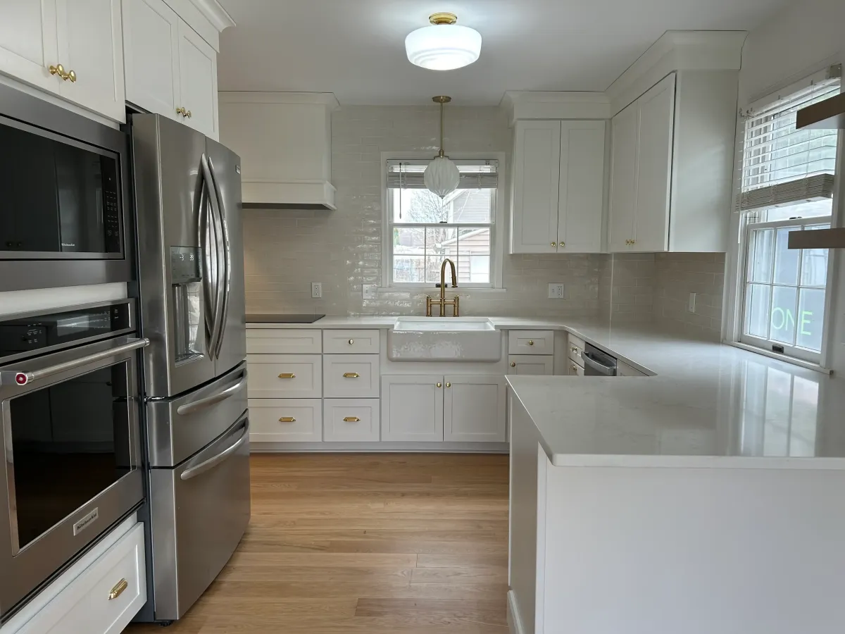 Custom kitchen design with navy island, shaker upper cabinets, and quartz countertops installed by Archstone Homes.