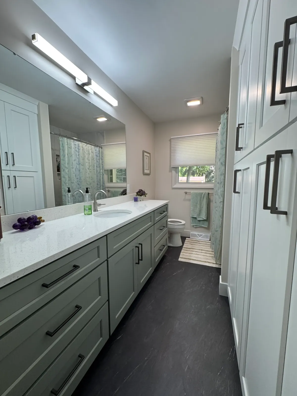 Bright custom bathroom remodel with double vanity and modern storage by Archstone Homes in West Michigan.