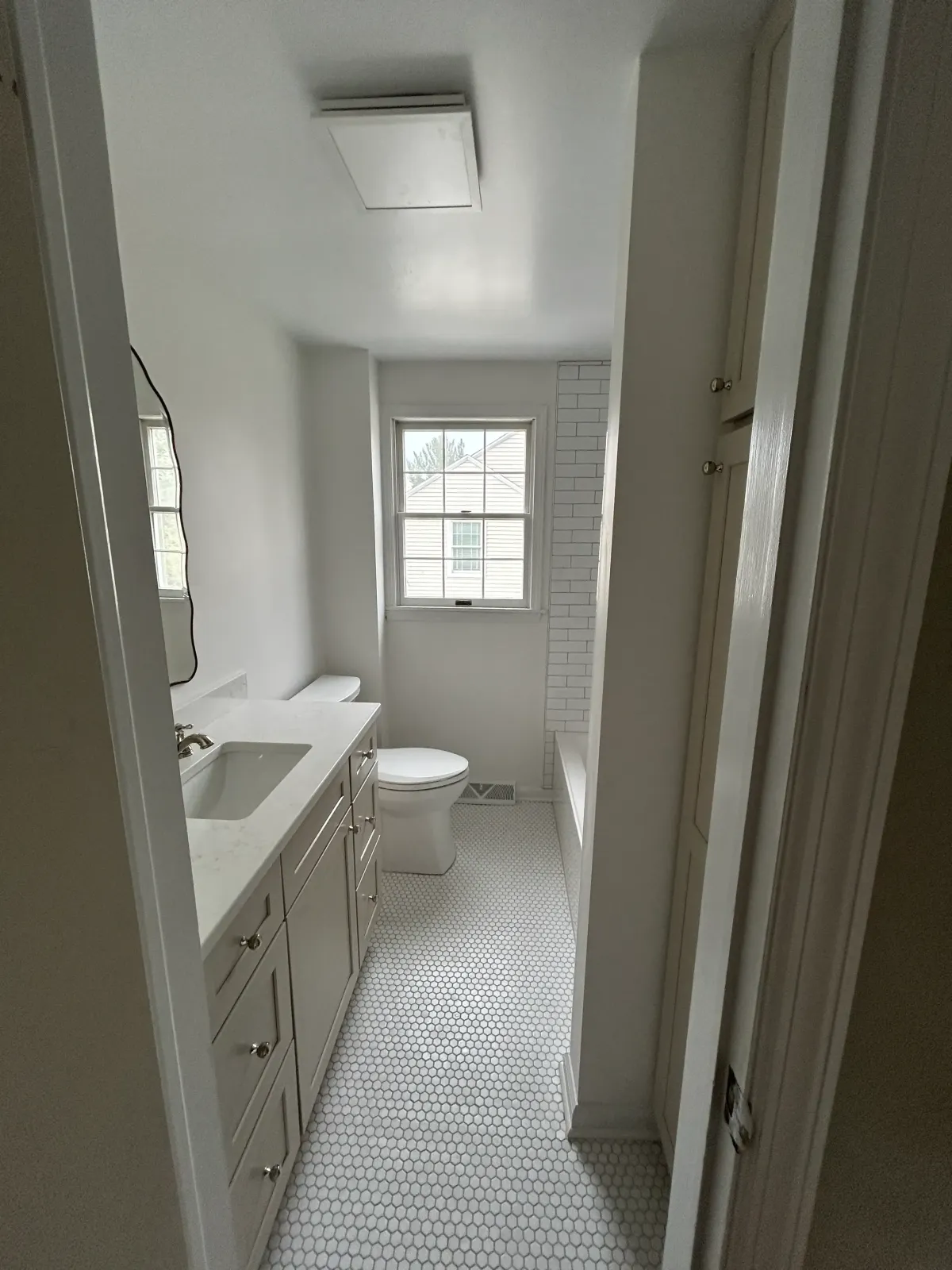 Small bathroom remodel featuring improved layout, updated fixtures, and tile accents.