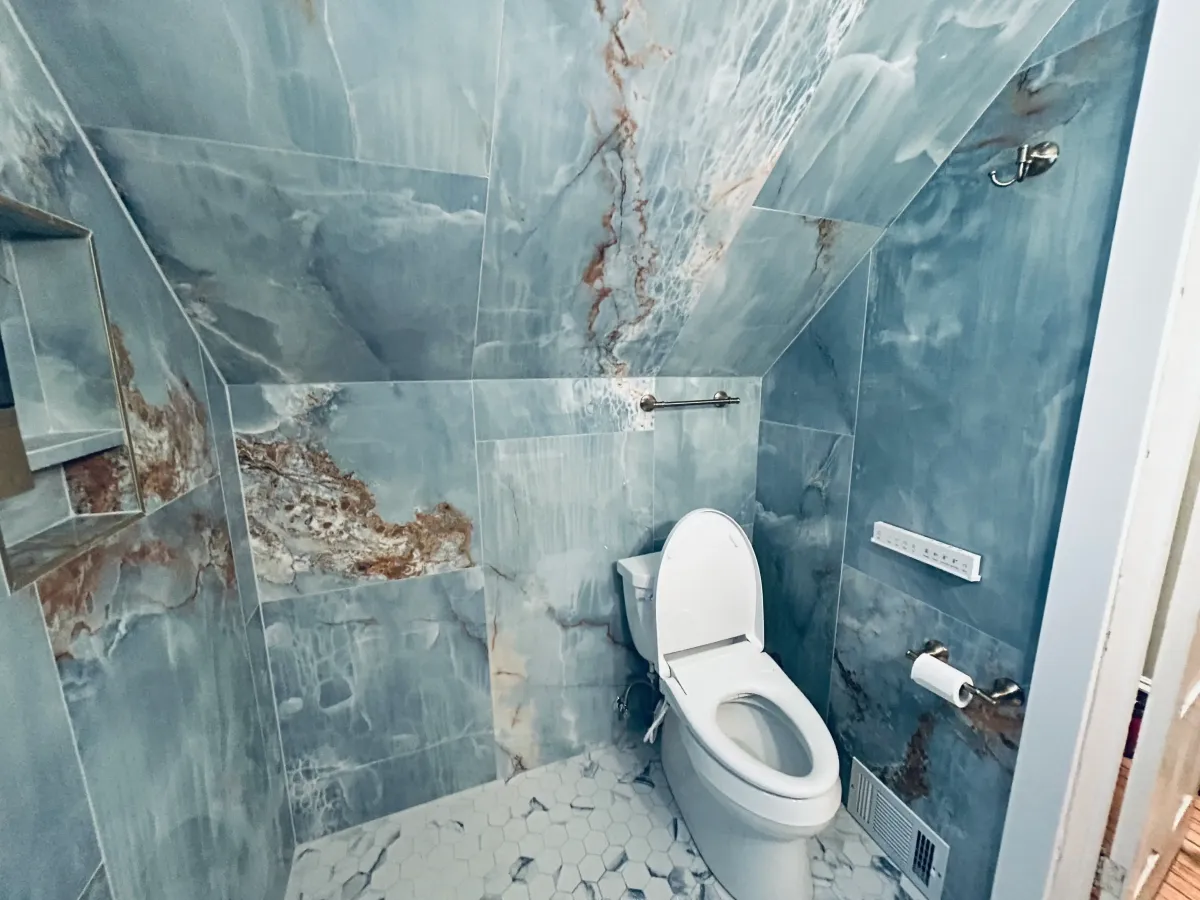 Bathroom demolition in a historic West Michigan home featuring a preserved stained glass window and careful removal of lath and plaster walls by Archstone Homes.