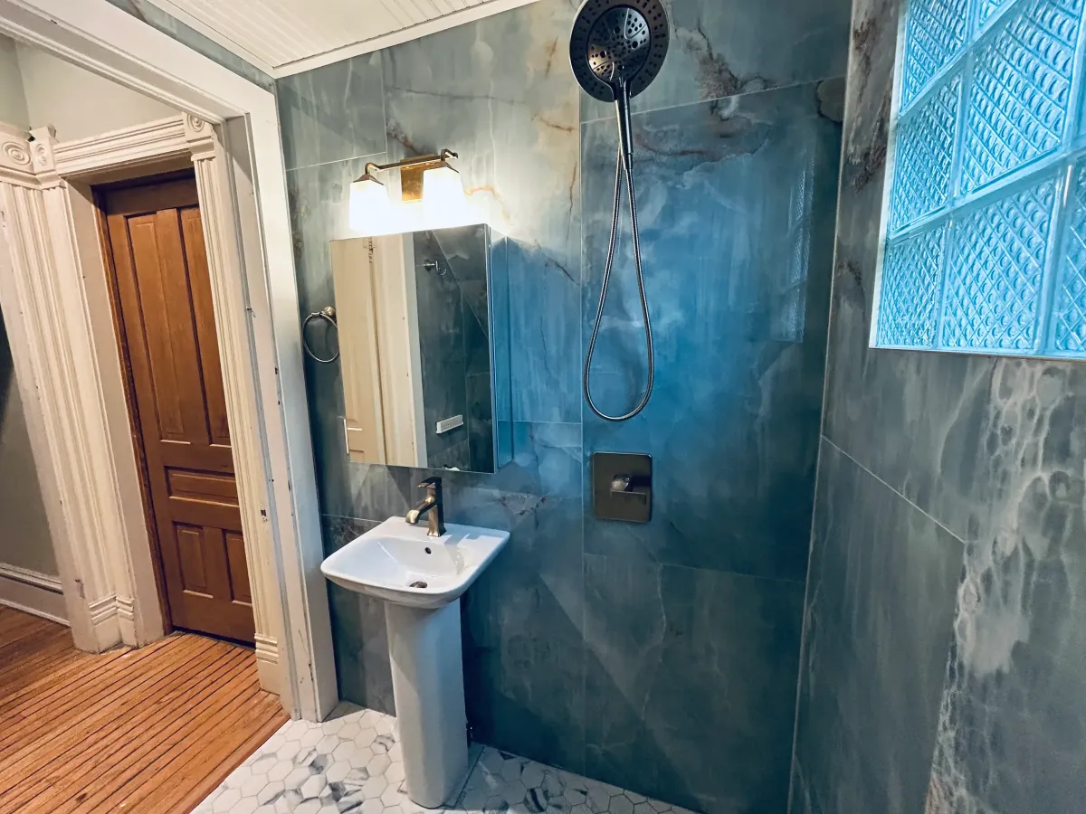 Bathroom remodel stripped to the studs showing structural framing and preparation for a high-performance waterproof locker room style shower system.