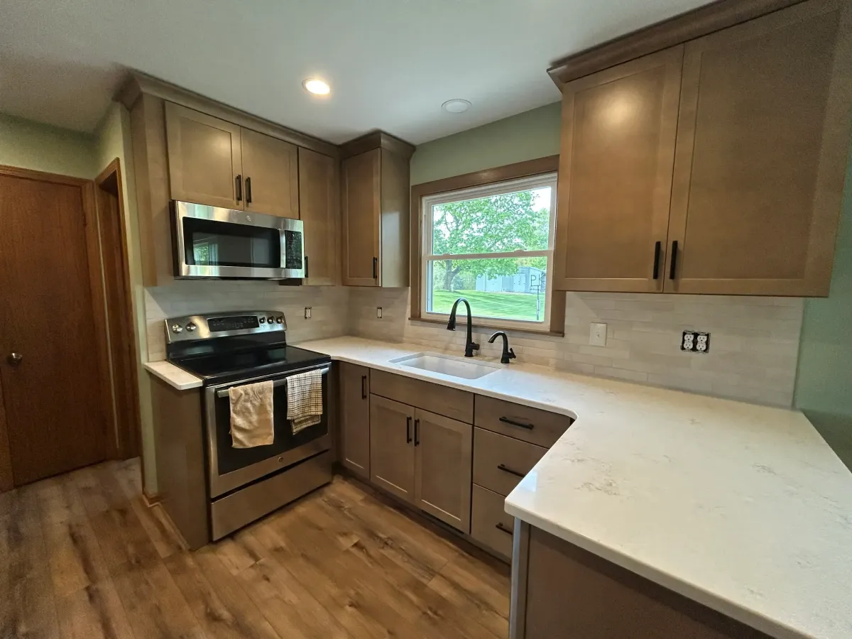 Completed kitchen remodel with white countertops and stainless steel range in Grand Rapids, MI