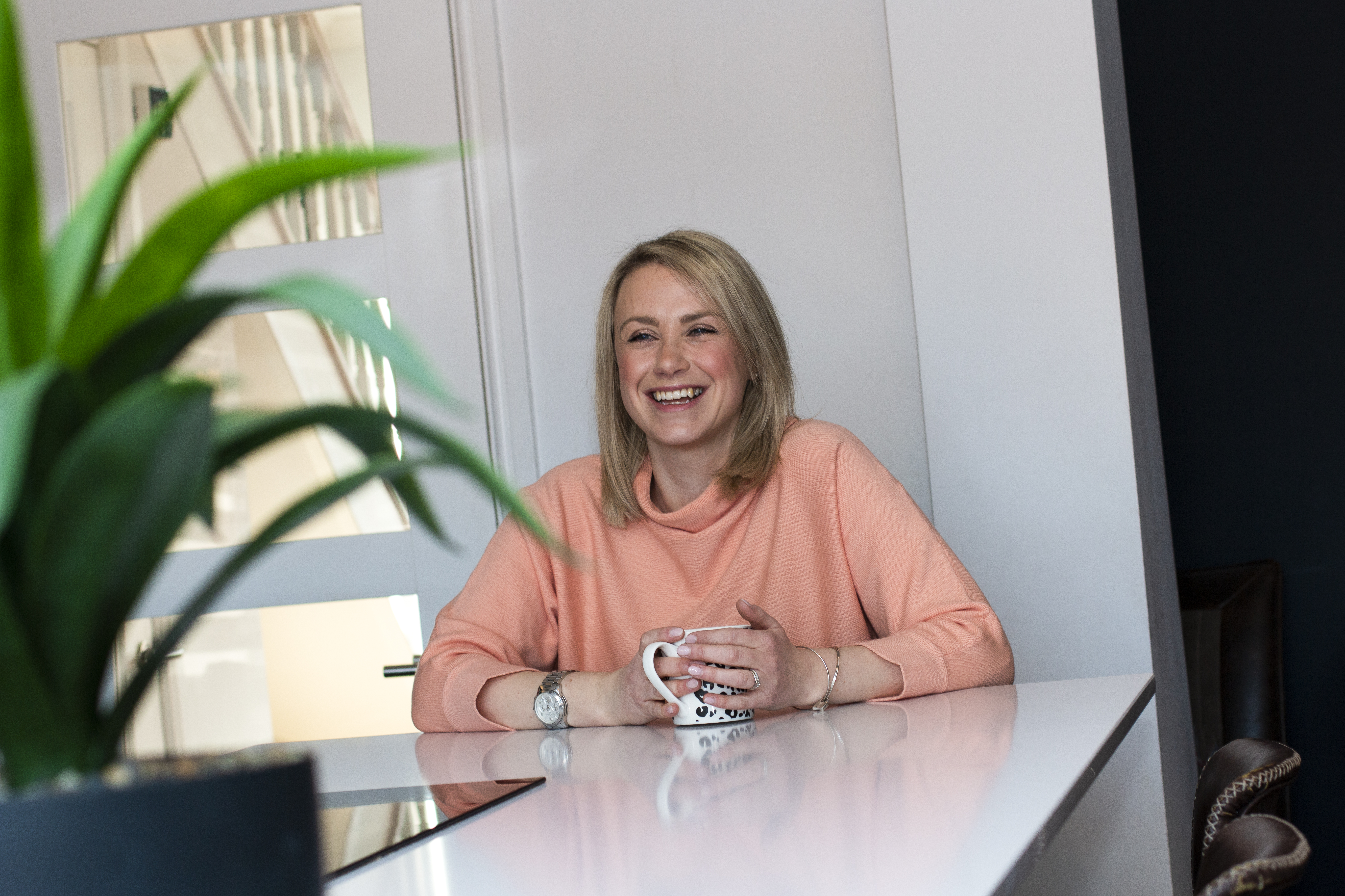 Daisy smiling relaxed with a coffee