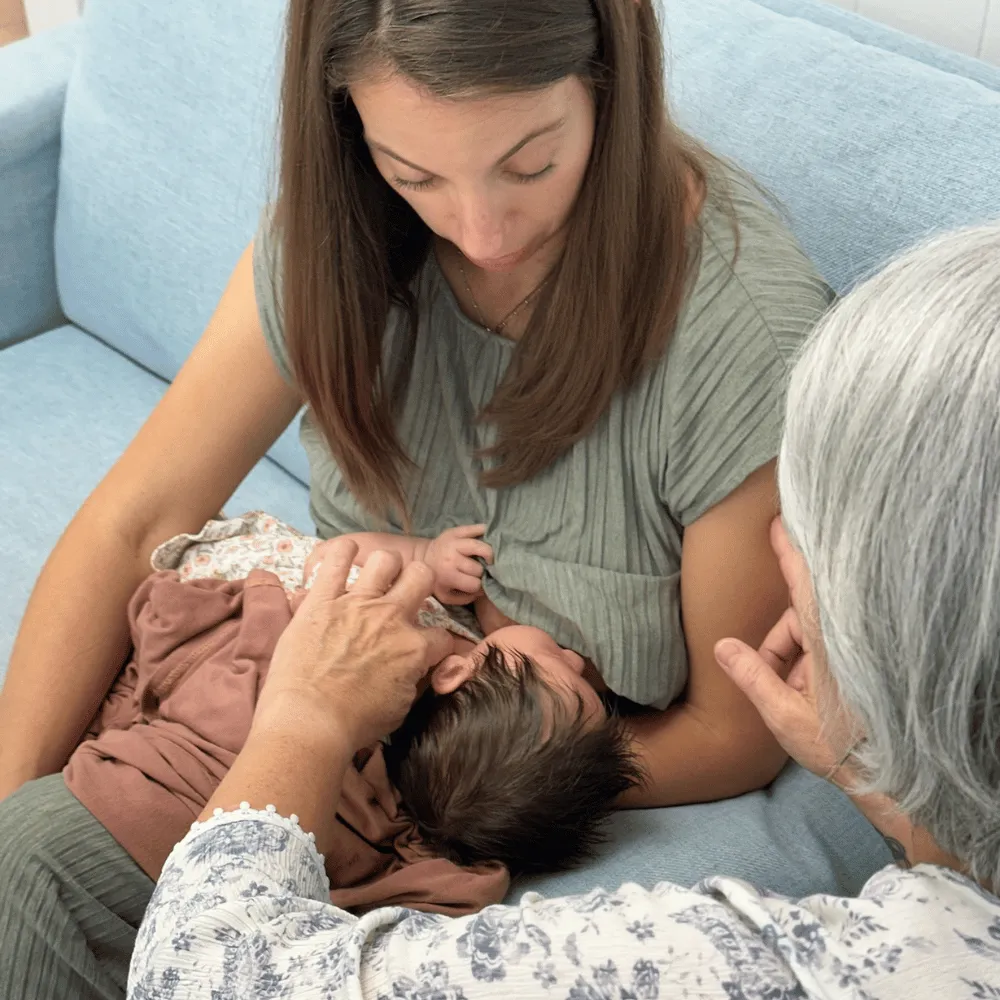 Mother holding newborn during a Craniosacral Fascial Therapy (CFT) consultation in Franklin, TN with hands-on support from a Blessed Beginnings lactation consultant.