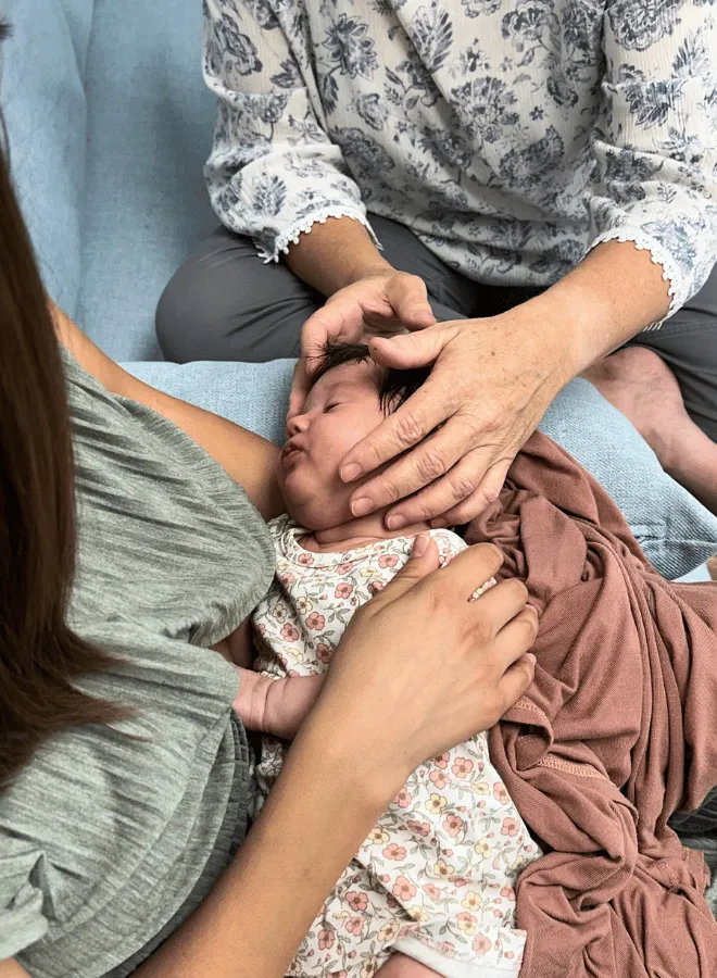 Infant receiving Craniosacral Fascial Therapy (CFT) during a lactation support session in Franklin, TN with hands-on care focused on feeding tension, latch support, and newborn comfort.