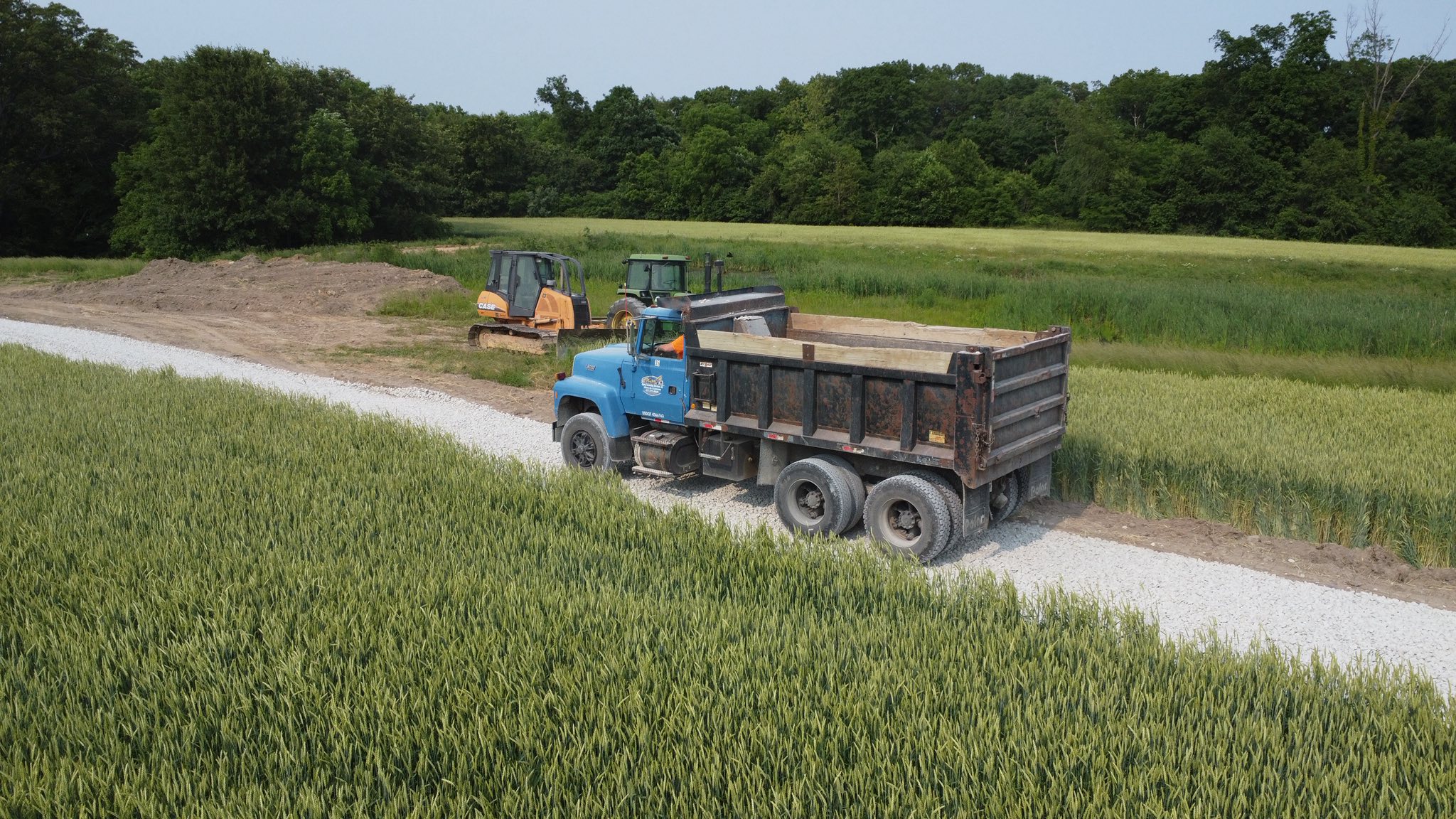 an excavator on a dirt field under a blue sky