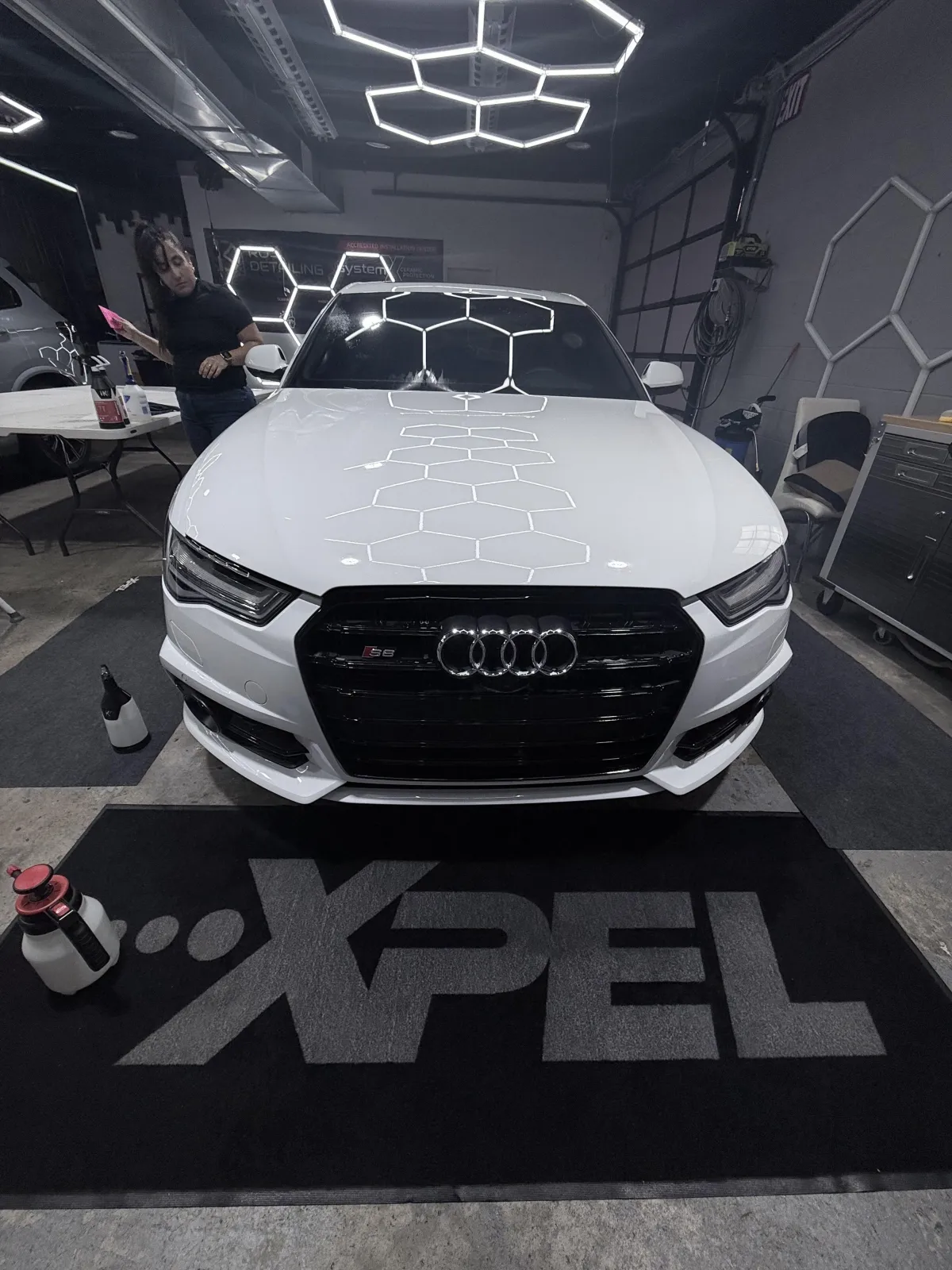 White Audi with XPEL paint protection film application in climate-controlled studio.