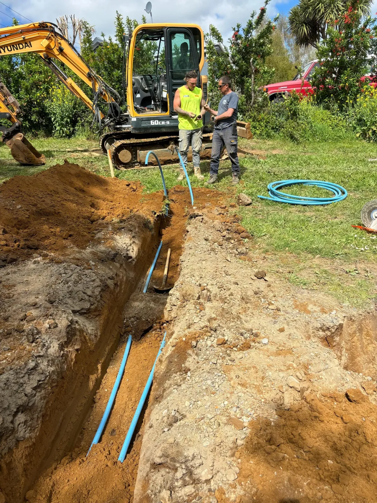 Excavator working on laying pipes for an infrastructure project, part of project management.