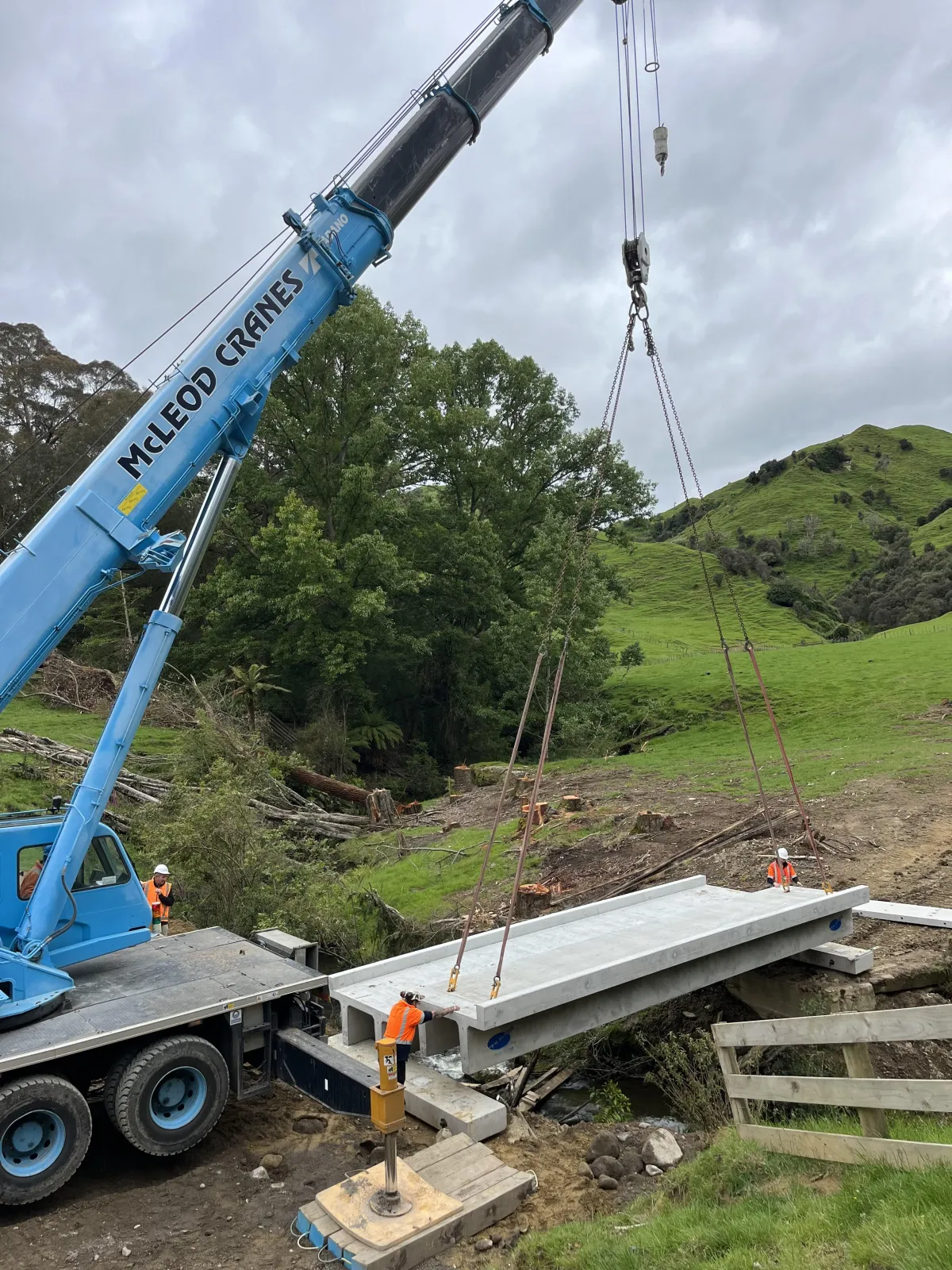 Crane lifting heavy materials for bridge construction on a rural project site in Ohakune.