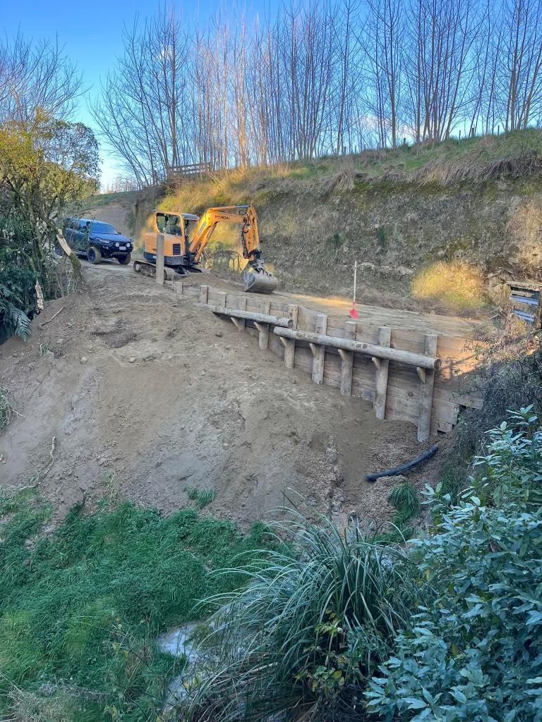 Excavator working on constructing a retaining wall for land development project in Ohakune.