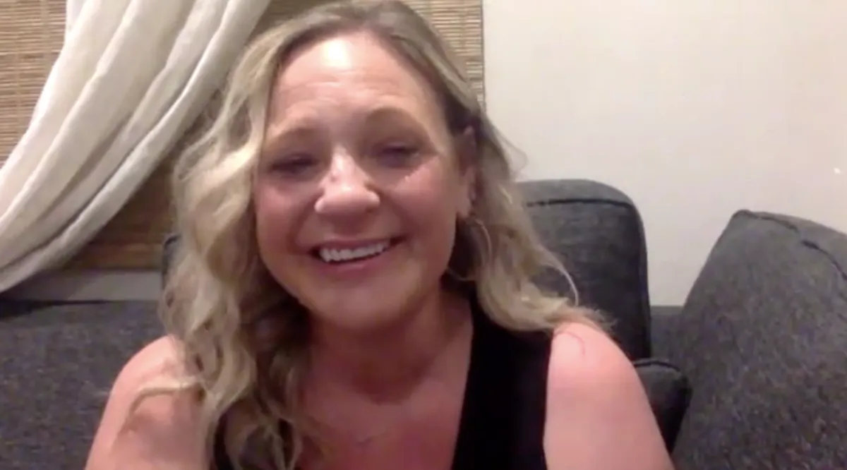 woman smiling during a video call, sharing her heartfelt reaction to her personalized song
