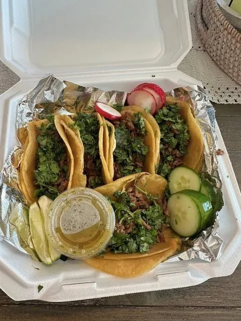 a plate of food on a table with a bowl of salsa