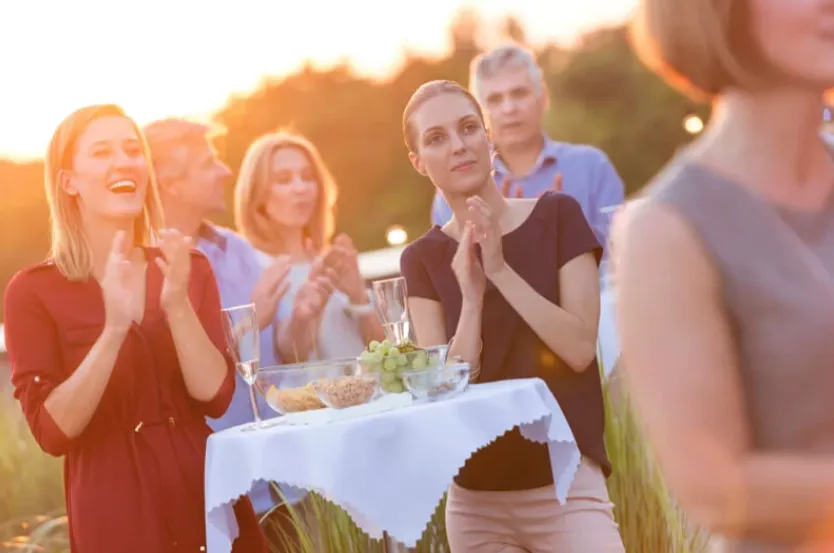 Performers dance on an outdoor stage with audience watching