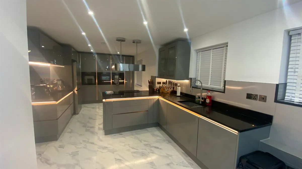 Modern luxury kitchen with induction hob and LED strip lighting — high-demand appliances requiring dedicated electrical circuits
